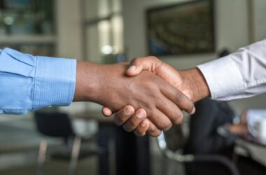 Two people shaking hands across a desk, representing a B2B supplier shortlist decision
