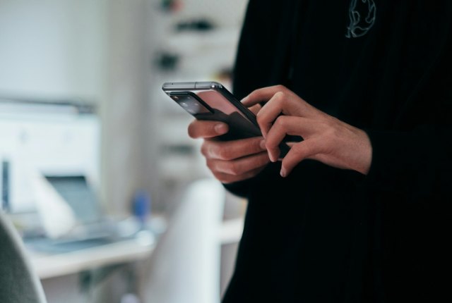 Person typing a long question into a phone search bar