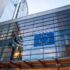 European Union flag reflected in a modern glass building