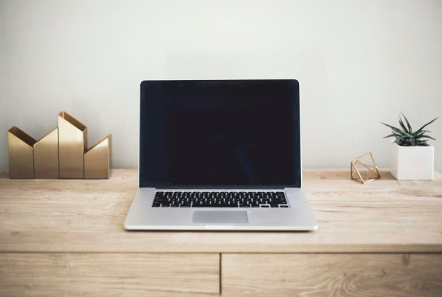 Laptop open on a desk with documents, representing AI editing live work files