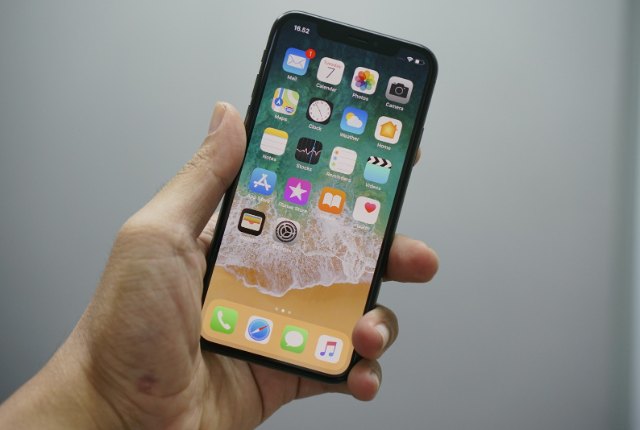 Hand holding a smartphone showing app icons, representing app consent prompts
