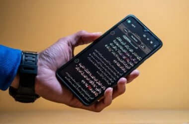 Hand holding a smartphone displaying text on screen