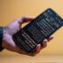Hand holding a smartphone displaying text on screen