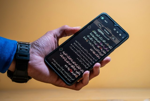 Hand holding a smartphone displaying text on screen